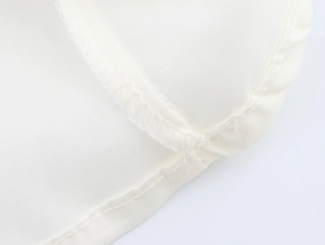 Gros plan sur la texture de la dentelle blanche et les coutures de la robe élégante