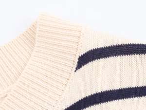 Détail du pull en maille rayé beige avec poignets côtelés et texture de haute qualité