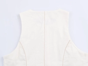 Gros plan des coutures contrastées sur haut blanc sans manches en tissu lisse
