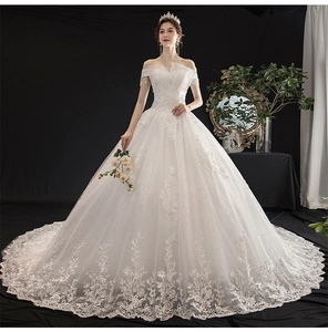 Detail of white off-shoulder bridal gown with luxury sequin lace and beaded fringe