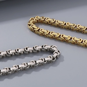 Close-up of 8mm titanium steel curb chain in gold and silver with woven texture