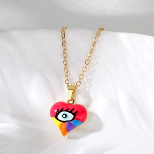 Detailed macro view of heart-shaped evil eye pendant with colorful enamel and gold finish