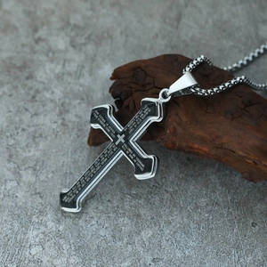 Macro shot of silver stainless steel cross pendant with Lord's Prayer on wood