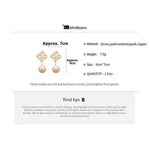 Detail view of gold-plated clover earrings with zircons, large pearls and silver pins