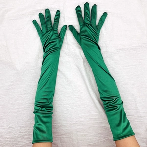 Dettaglio dei guanti lunghi in raso verde smeraldo con finitura lucida e tessuto elastico