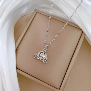 Macro shot of silver pumpkin carriage necklace with sparkling crystals in a jewelry box