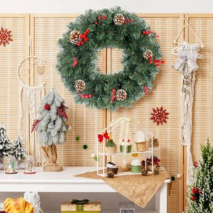 Classic Christmas wreath with green pine needles, red berries and natural pine cones