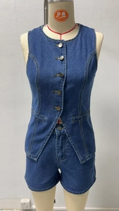 Dettaglio del gilet di jeans senza maniche con bottoni in metallo e pantaloncini abbinati