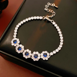 Gros plan d'un bracelet fleurs en zircon bleu sur un coffret à bijoux en cuir noir