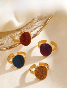Close-up of four vintage oval enamel adjustable rings in gold-plated stainless steel