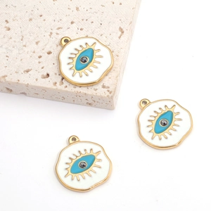 Three evil eye stainless steel pendants with gold rim and blue enamel on stone background