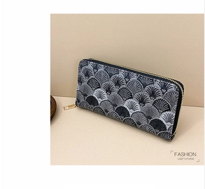 Close-up of long wallet featuring grey embroidered scalloped patterns and gold zipper