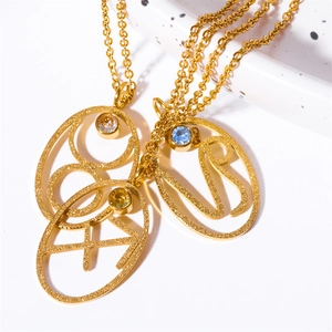 Gold stainless steel zodiac necklaces with oval turquoise pendants on a ceramic tray