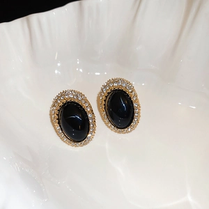 Macro detail of vintage oval stud earrings with black stone and sparkling rhinestones