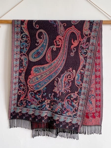 Detail of dark purple cashmere-style shawl with ethnic paisley patterns and fringe