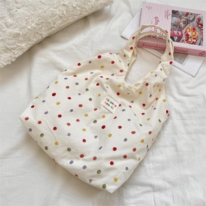 Vue détaillée des pois colorés sur le tissu en toile beige résistant du sac cabas
