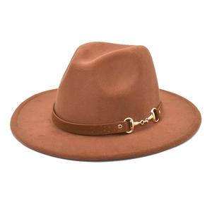 Detail of camel wool fedora hat featuring a brown leather band and gold horsebit buckle