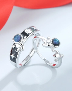Macro shot of S925 silver astronaut couple rings with blue enamel space details
