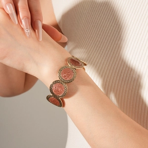 Close-up of leopard pattern round disc bracelet in vintage gold finish on a wrist