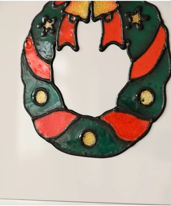 Détail d'autocollant de couronne de Noël avec feuilles vertes et paillettes dorées