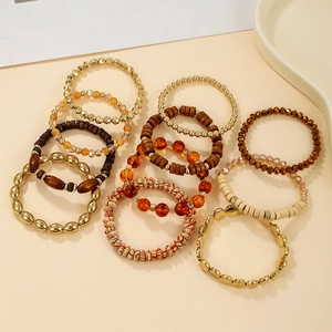 Close-up of layered bohemian beads featuring gold metal and warm wooden textures