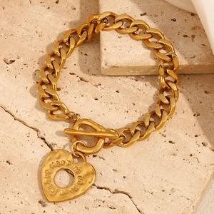 Détail du bracelet chaîne gourmette plaqué or 18K avec pendentif cœur et fermoir OT