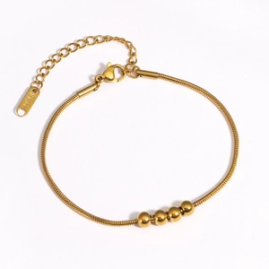 Détail du bracelet chaîne serpent dorée avec quatre perles et fermoir mousqueton réglable