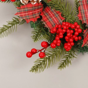 Christmas wreath with red berries, pine needles and checkered leaves decoration