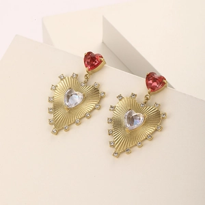 Detail of gold-plated stainless steel heart earrings with red and clear zircon stones