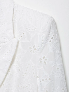 Détails de broderie florale et design évidé sur un blazer blanc à col châle