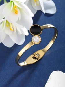 Detail of gold-plated stainless steel bangle with enamel and shell round inlays