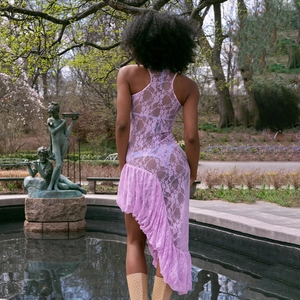 Détail d'une robe sans manches en dentelle violette avec ourlet à volants et motifs