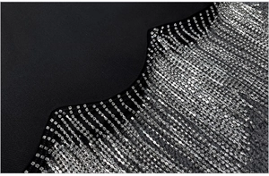 Detailed macro view of silver rhinestone fringe on a black high-waisted skirt suit set