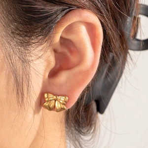 Elegant gold bow-shaped stud earrings in polished stainless steel with vintage texture