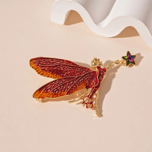 Detail of fairy brooch with red enamel gradient wings and gold metal star decor