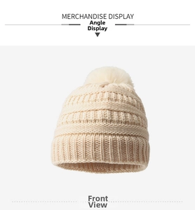Gros plan du bonnet en maille crème avec un pompon moelleux et une texture côtelée