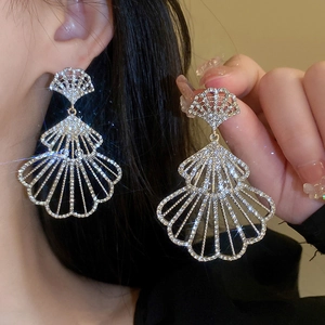 Elegant silver fan-shaped tassel earrings with sparkling crystals shown on a model