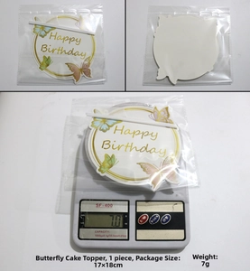 Close-up of a butterfly birthday cake topper with gold trim and weight measurement