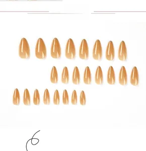 Detail of 24pcs long almond press on nails in nude with golden glitter tips