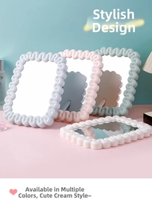 Detail view of wavy cream style makeup mirror with foldable stand in macaron colors