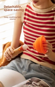Close-up of assembling the warm LED night light with orange silicone shade and wood handle