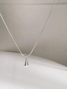 Close-up of a sleek S925 sterling silver teardrop pendant on a smooth snake chain
