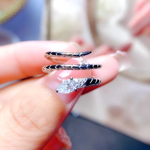 Macro detail of silver snake ring featuring pear-cut diamond and black enamel texture