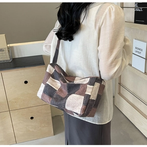 Détail du sac à bandoulière en denim montrant des motifs à carreaux marron et gris