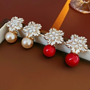 Detailaufnahme der Blumenohrringe mit Perlen und Kristallen in Gold und Rot
