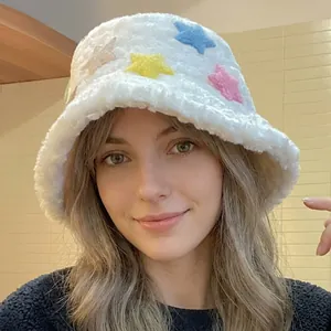Détail d'un chapeau bob en peluche blanche avec broderies étoiles et texture douce