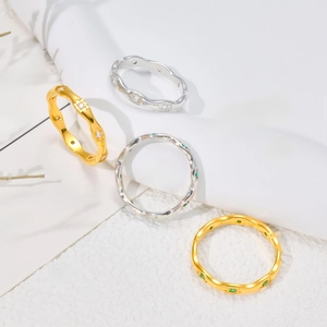 Detailed view of wave-edge stainless steel rings with star engraving and colorful zircons