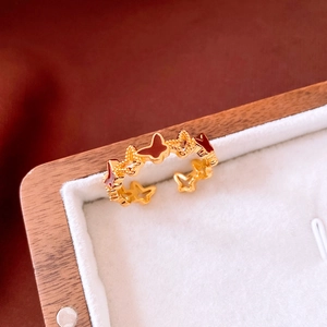 Vue détaillée d'une bague papillon plaquée or 18 carats avec émail rouge et texture creuse