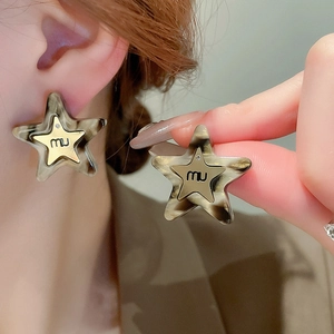 Detailed view of leopard print star earrings with gold plating and resin texture