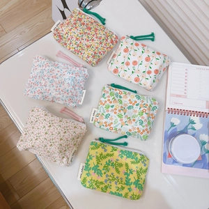Set of six floral cotton coin purses with zipper closure and wrist strap on a desk